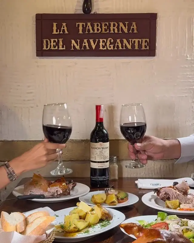 Mesa con vino tinto bajo el letrero de La Taberna del Navegante